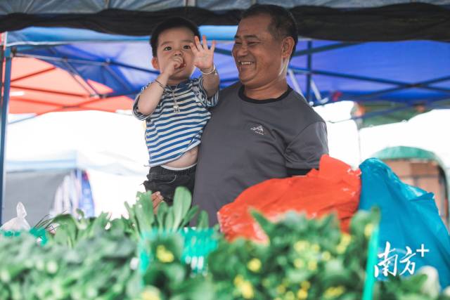 博社村市场的一位档口老板抱起孙子，满脸幸福。 记者 罗一飞 摄