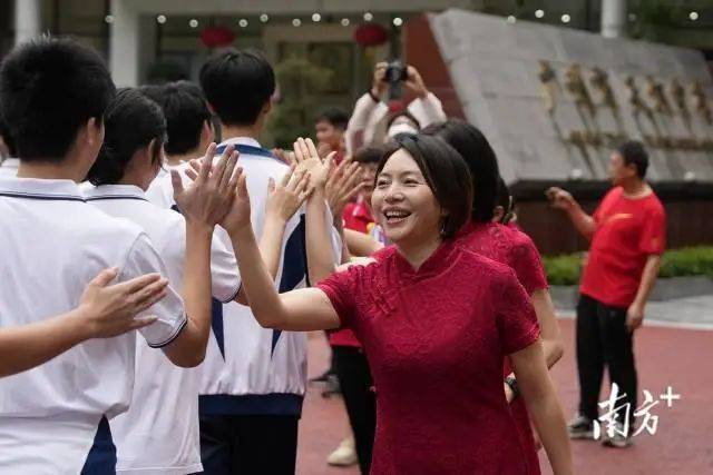 广州市天河区天河中学考点，老师与考生们击掌鼓气。