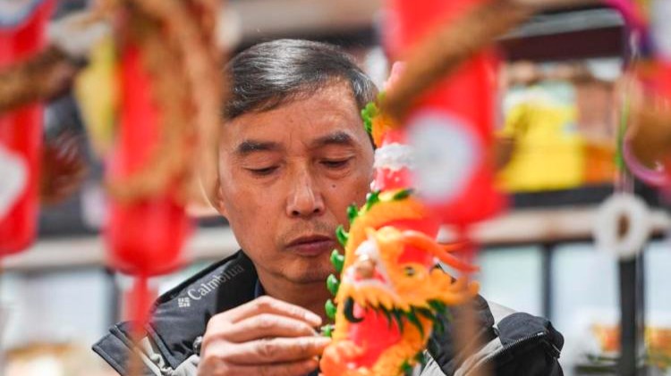 InPics: Inheritor promotes traditional dragon and phoenix candles via innovation