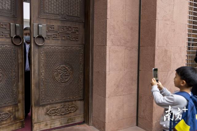 一名男孩用手机拍下闭馆时关门一瞬，象征着这座老艺博院正式与市民暂别。
