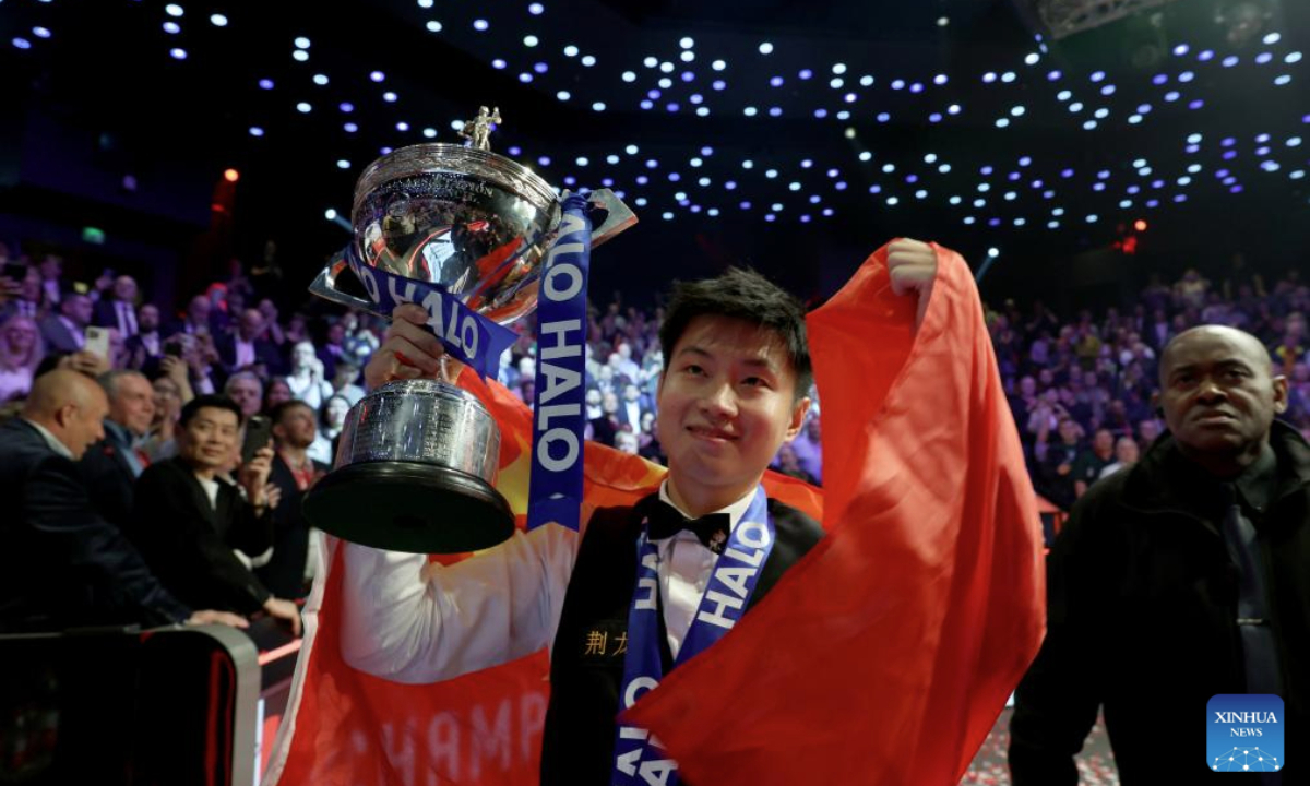 Zhao Xintong celebrates with the trophy after claiming the title by defeating Mark Williams of Wales in the final at World Snooker Championship 2025 in Sheffield, Britain, May 5, 2025. (Photo by Zhai Zheng/Xinhua)