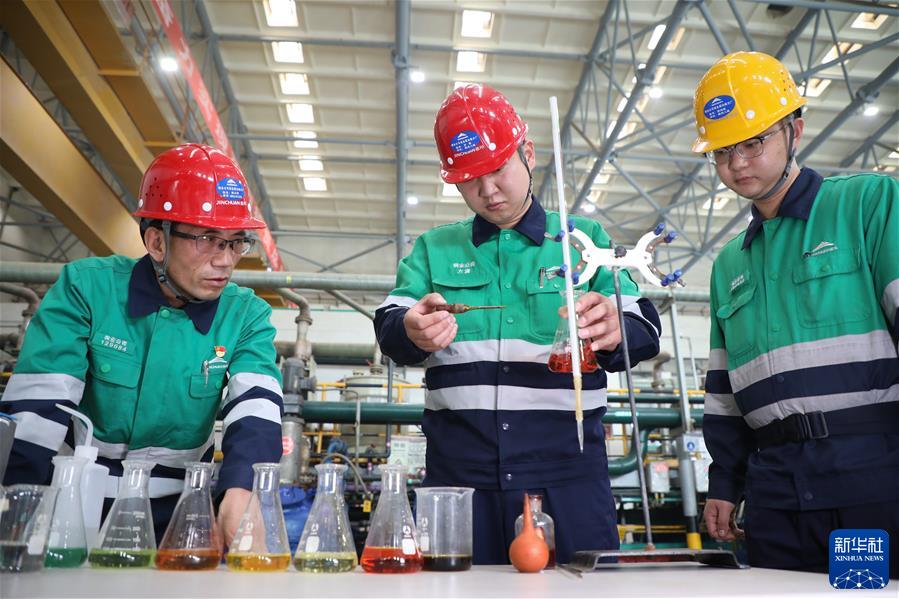 　　在甘肃省金昌市金川区，金川集团铜业有限公司贵金属冶炼分厂提纯工序工序长潘从明（左）在生产现场指导职工进行实验（2022年9月21日摄）。新华社记者 马希平 摄