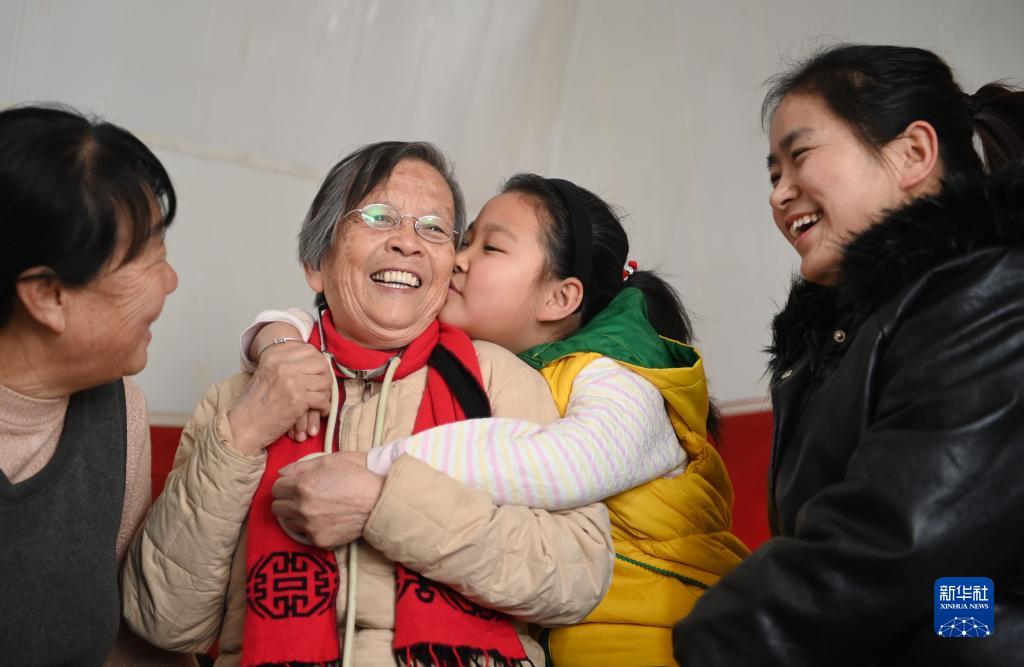 　　路生梅（左二）在陕西佳县佳州街道凌云社区义诊时，张宇旋亲密拥抱她（2021年1月17日摄）。张宇旋的妈妈（右一）、奶奶（左一）都曾让路生梅看过病。新华社记者 陶明 摄