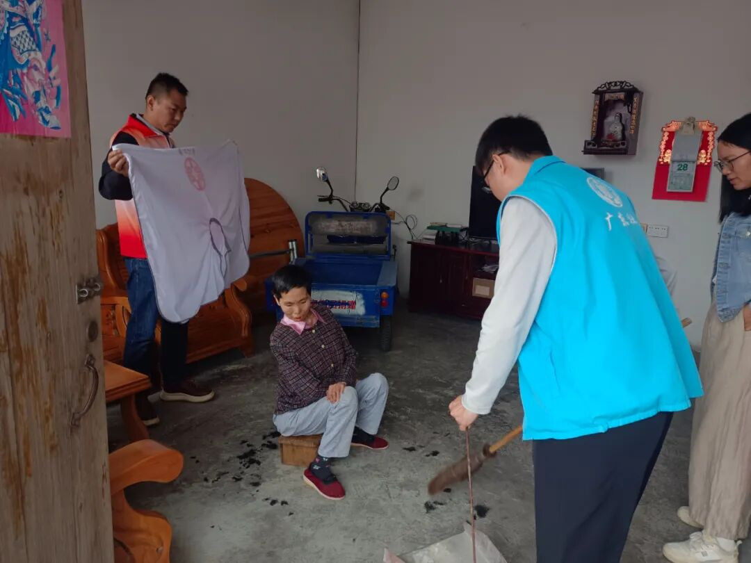 志愿者们帮助老人打扫屋子。(摄影:房丽珍)