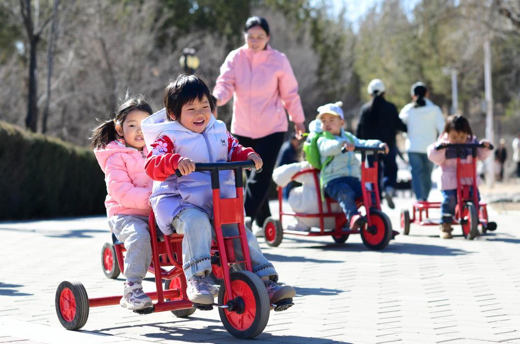 △2025年3月19日，在内蒙古鄂尔多斯康巴什区一所托育园，老师陪伴孩子做体能游戏。