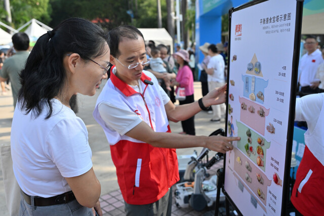 活动现场,工作人员正在为市民解读平衡膳食宝塔。