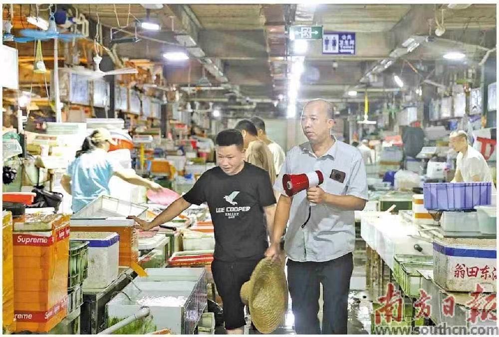 湛江霞山海鲜水产批发市场关停,工作人员组织商户离场。南方日报记者 王俊涛 摄