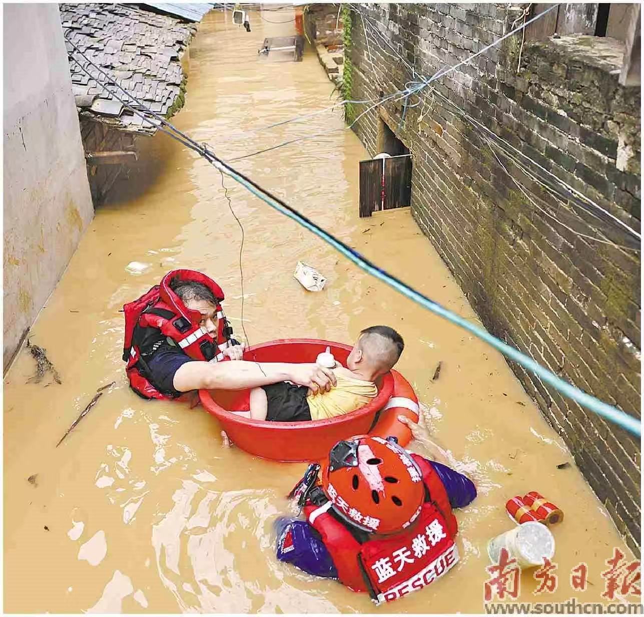 6月18日,肇庆市怀集县怀城街道,广东蓝天救援队在水中转移发高烧的男孩小麦。