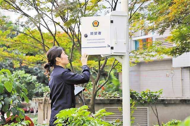 民警在九龙坡居民小区调试“瞭望者”高空抛物智能预警监控系统。