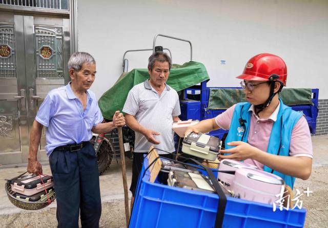 5月19日中午，抵达送饭地点后，连樟村90后社工刘华达从摩托车上为老人取出饭盒。