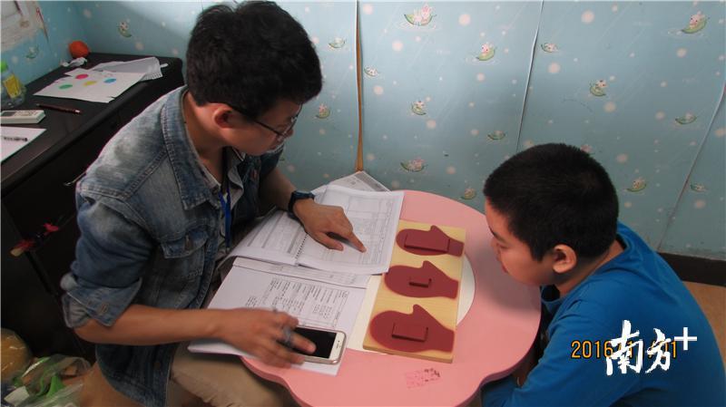 夏健思正与自闭症儿童进行沟通。图片来自于江门市特殊教育学校