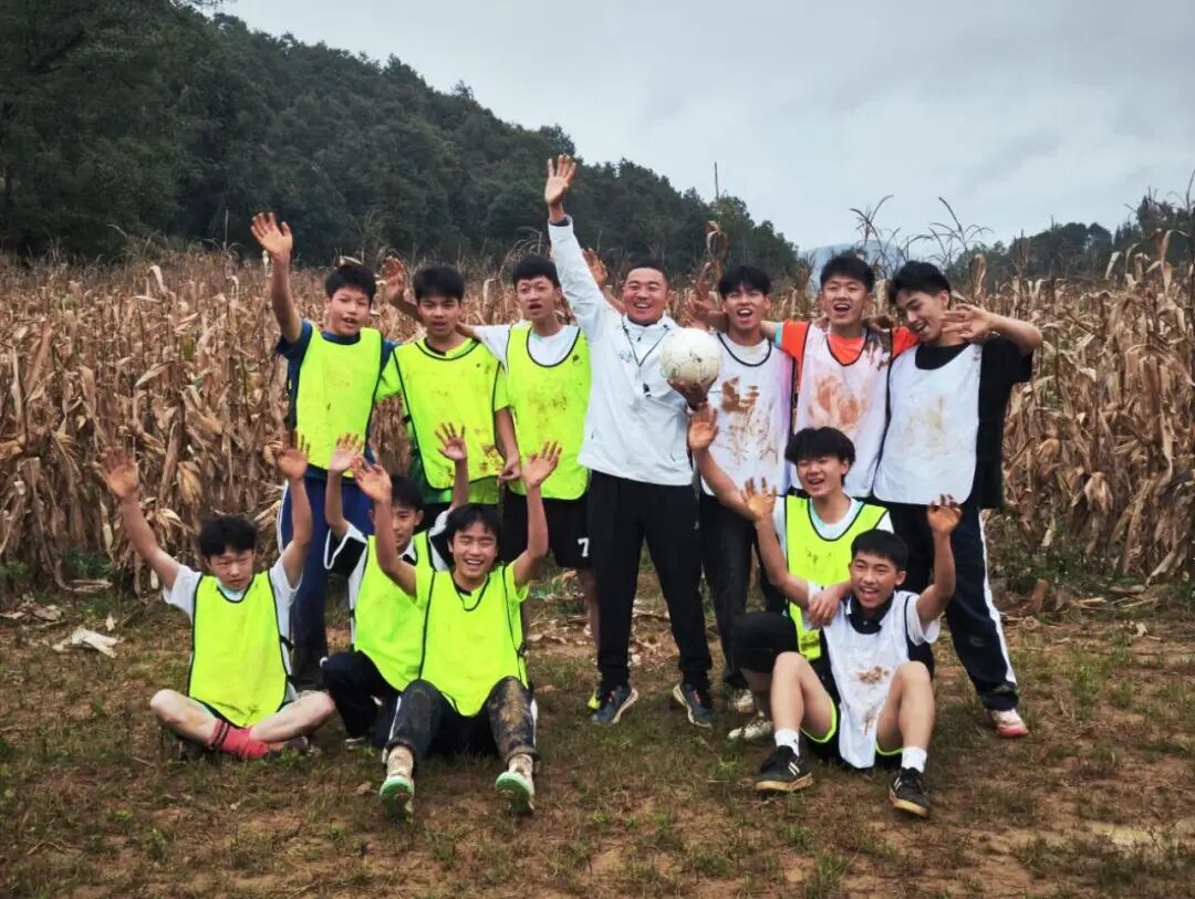 贵州普安县罗汉中学校长欧阳谦带着学生在玉米地里踢球。(受访者供图)