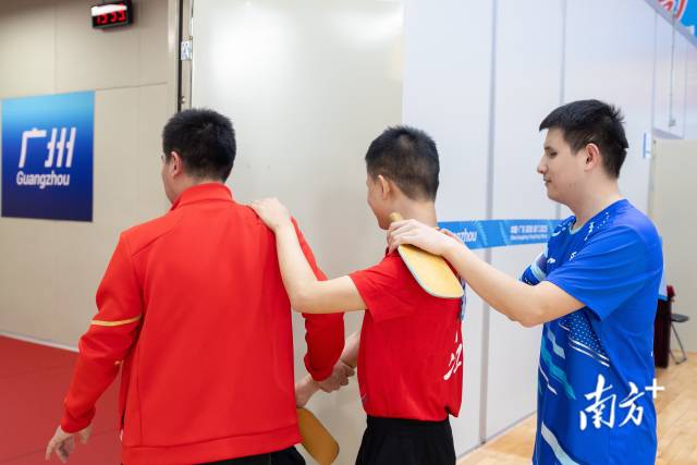 选手扶着教练肩膀进入场地训练。 选手扶着教练肩膀进入场地训练。