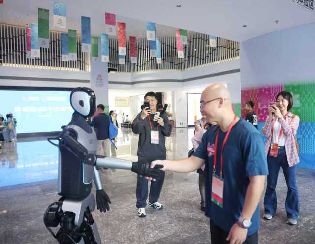 参会记者在媒体中心与机器人互动 南方+记者 段奇 摄