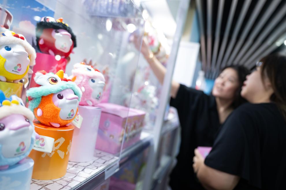 ↑8月1日，市民在十五运会和残特奥会澳门赛区官方特许商品零售店选购。新华社发（张金加摄）