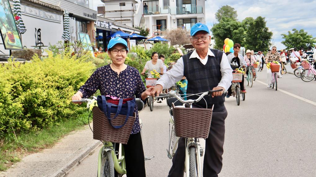 7月5日，一对已经退休的越南夫妻在大理洱海边骑行。 新华社记者 王贤思 摄