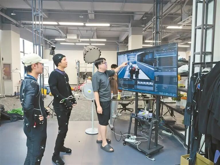李锴滨（右一）与团队成员讨论作品细节。 受访者供图
