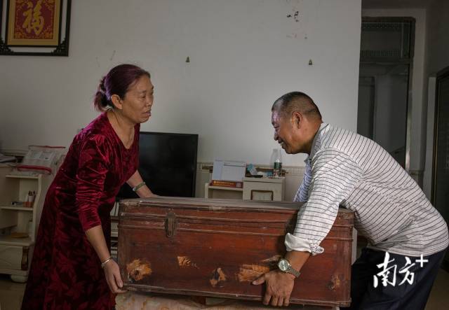 卢先秀和丈夫搬出一个老旧的行李箱,她说这是当年父亲给的嫁妆,走到哪都要带着。 卢先秀和丈夫搬出一个老旧的行李箱,她说这是当年父亲给的嫁妆,走到哪都要带着。