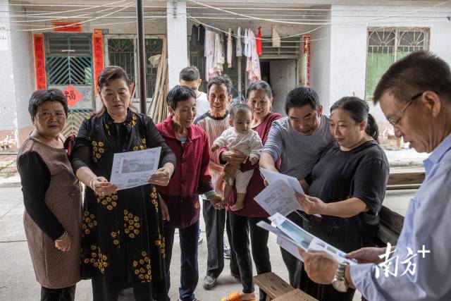 肇庆四会市西合村,移民村的村民们看着20年前南方日报对他们的报道,兴奋不已。 肇庆四会市西合村,移民村的村民们看着20年前南方日报对他们的报道,兴奋不已。