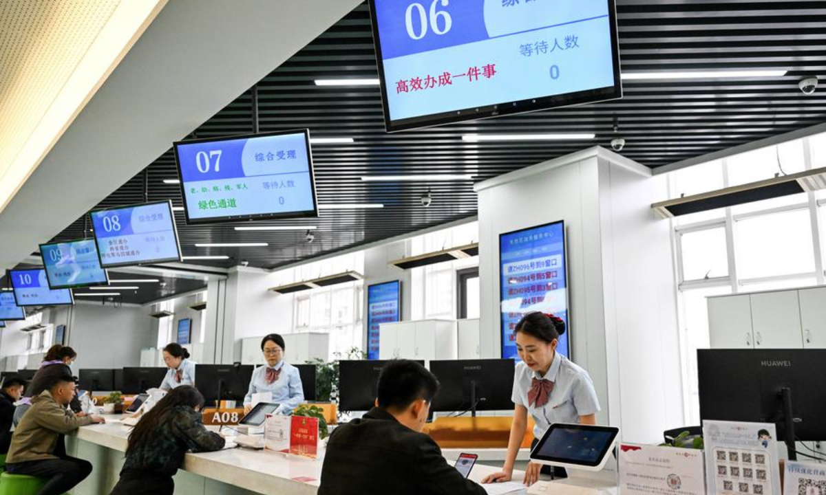 2025 年 4 月 16 日，中国北部内蒙古自治区鄂尔多斯市东升区政务服务中心，工作人员在处理与私营企业相关的业务。（新华社/李志鹏）