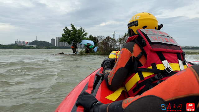 消防员救援被困浅滩的群众