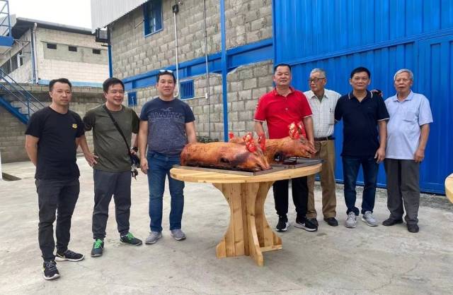 △委内瑞拉华商企业开张，用大红烧猪祈祝生意兴隆。