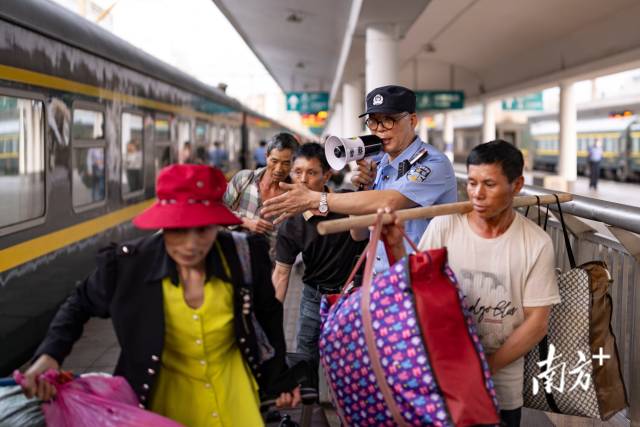 在月台上，叶国伟在人群中引导旅客上车。