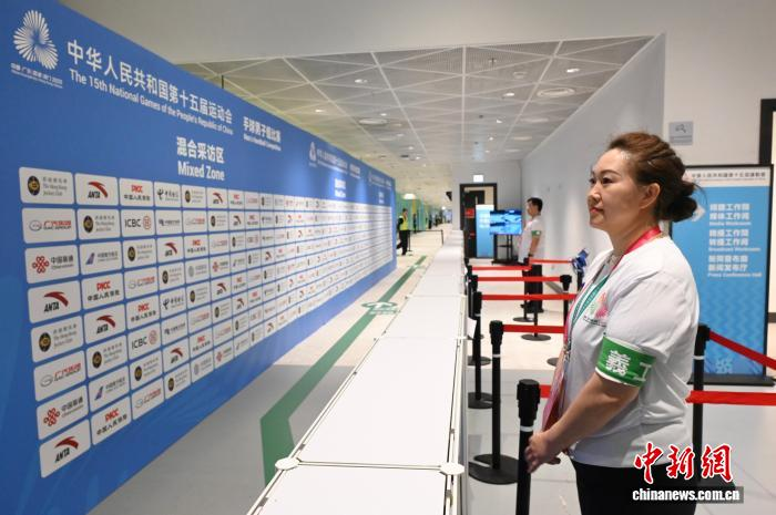 11月7日，义工王峡(右)在十五运会香港赛区男子手球项目混合采访区工作。 中新社记者 李志华 摄