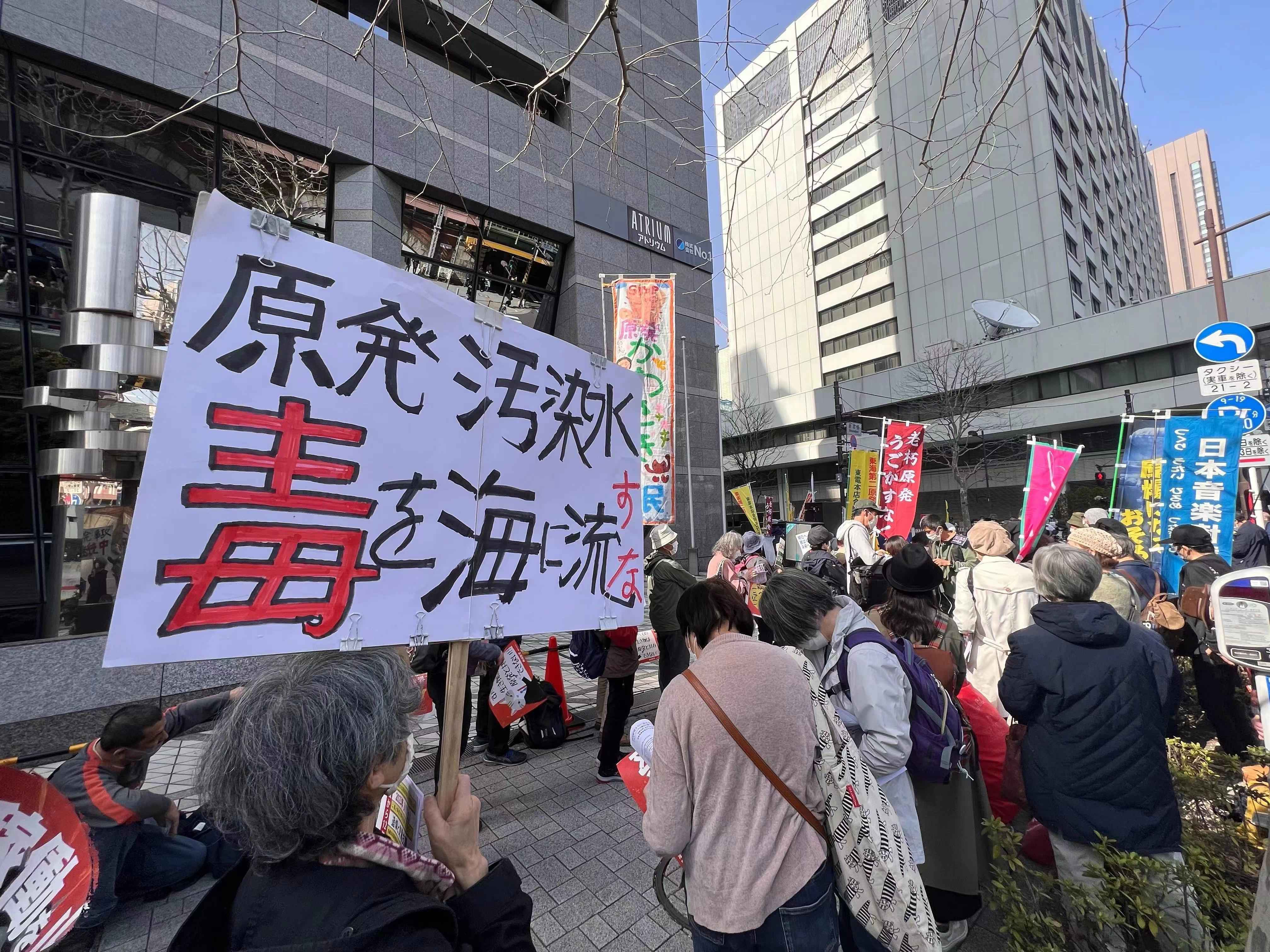 3月11日下午，日本民众在位于东京内幸町的东京电力公司总部大楼（注：远处白色大楼）附近举行集会抗议日本政府和该公司强推福岛核污染水排海计划。