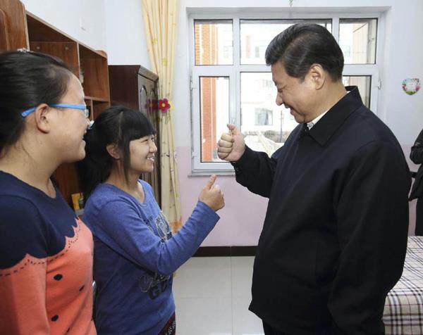 　　△2014年1月28日，习近平总书记在内蒙古呼和浩特市儿童福利院宿舍向聋哑女孩王雅妮（左二）和放假“回家”的大学生闫志净学习哑语“谢谢”。