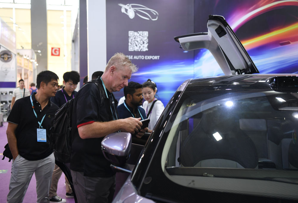 2023年10月16日,外国采购商观看广交会中国新能源汽车展台。新华社记者 邓华 摄