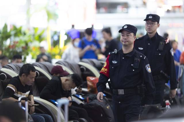 张锦锋（前）和陈滔（后）在广州南站内巡逻。 