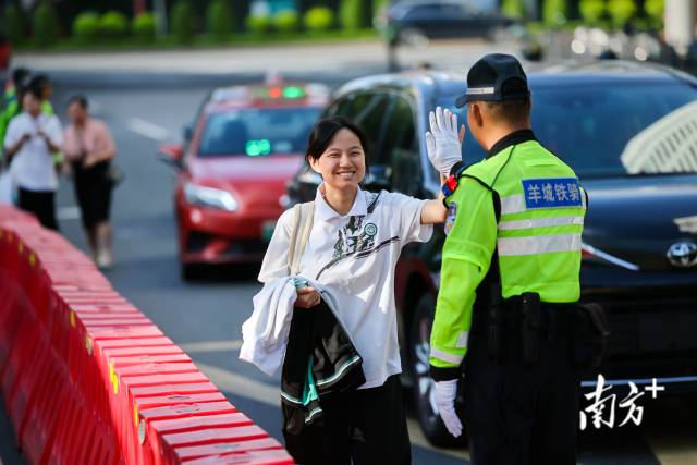 在执信中学考点，广州交警击掌鼓励考生。