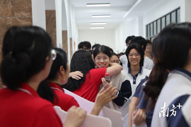 6月7日上午，在中山市永安中学考点，高三的老师身穿红衣服与考生轮流击掌，为首届1100余名高三学子送考。
