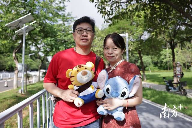 早上9时许，广大附中考点门口，考生家长郑先生和周女士带着女儿的两个玩偶前来送考。