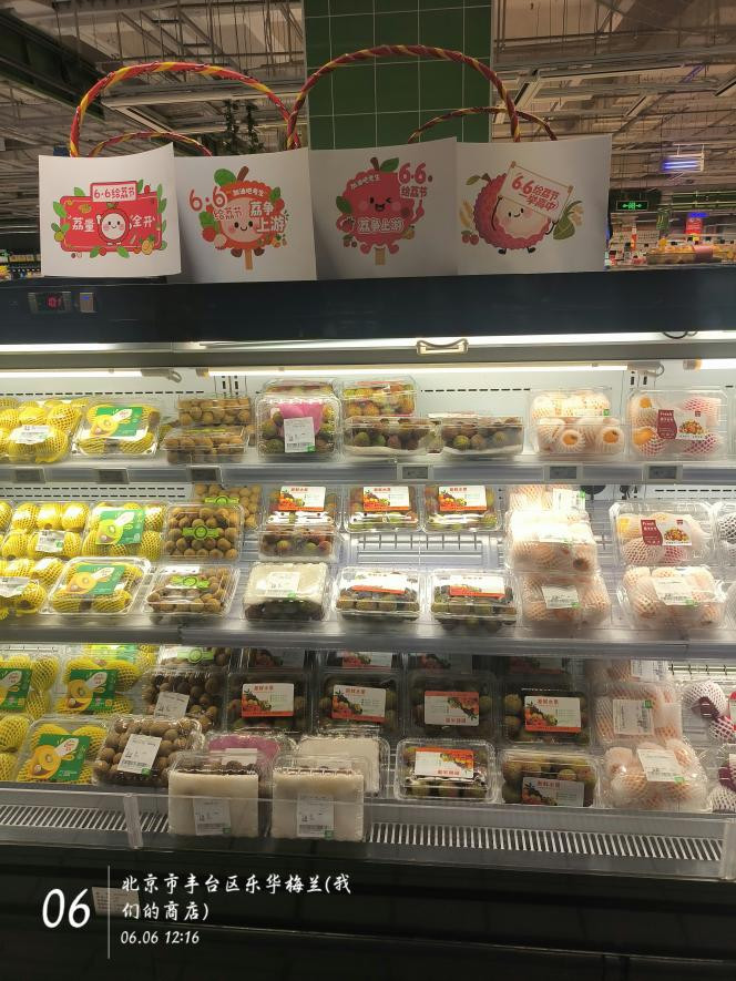 北京市丰台区的商店货架上摆放着荔枝，“6·6给‘荔’节”的宣传物料显眼。