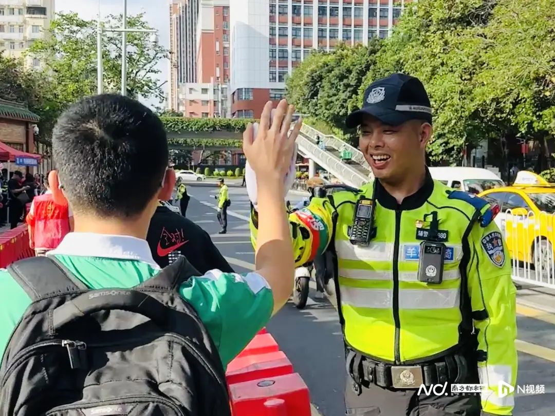 早上8时许，在执信中学考点的羊城铁骑与赴考学生击掌，给考生送上鼓励。