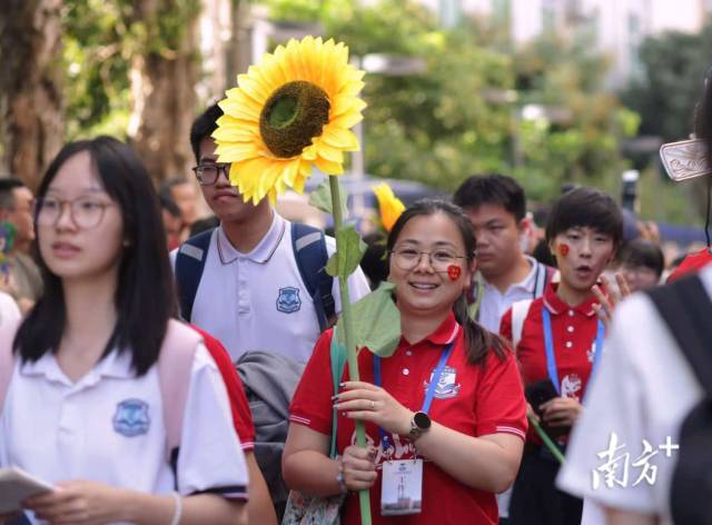 早上七时许，广州市第六中学门前，朝阳下陆陆续续有参加高考的学生等待走进考场。
