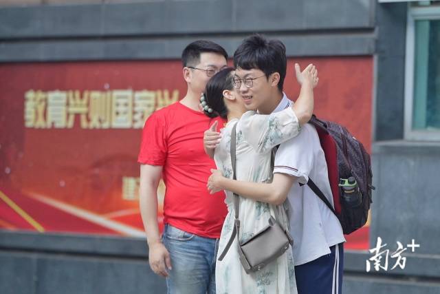 在佛山南海桂城中学考点，学生们陆续进场，送考的家长用拥抱为考生加油打气。