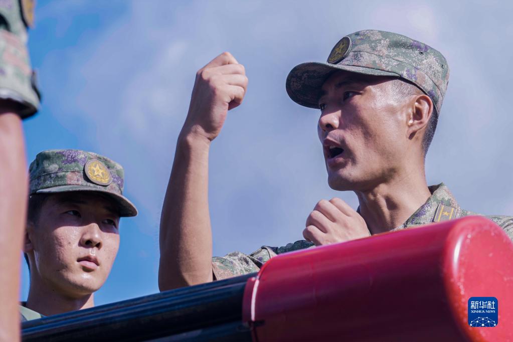 　　驻香港部队某团防空营营长王海旭（右）给新战友讲解火炮维护要点（2022年7月20日摄）。新华社发（田越洋 摄）