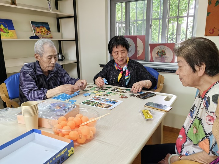 5月27日，上海市普陀区真如镇街道一家老年人日间照料中心内，老人们正在玩拼图游戏。新华社记者吴振东 摄
