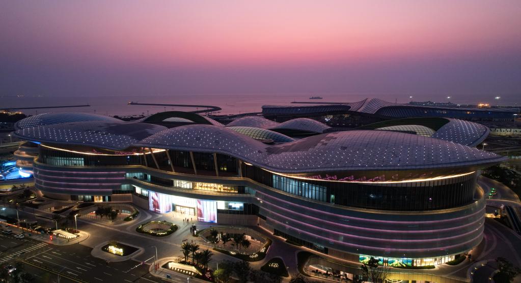 夜色中的海口国际免税城（前）和海口新海港客运综合枢纽项目（后）（4月4日摄，无人机照片）。新华社记者 杨冠宇 摄