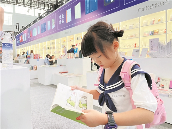 一名小读者在广东展馆翻阅儿童读物