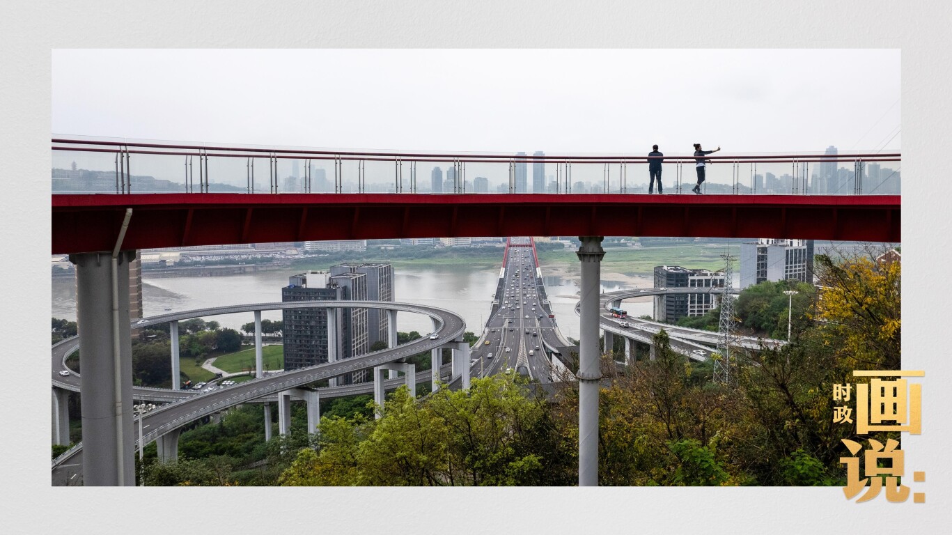 市民在苏家坝立交桥前留影，繁忙的跨江大桥通向城市远方。