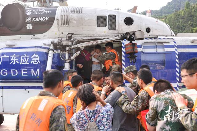 应急人员带领当地居民乘坐直升机转移。  
