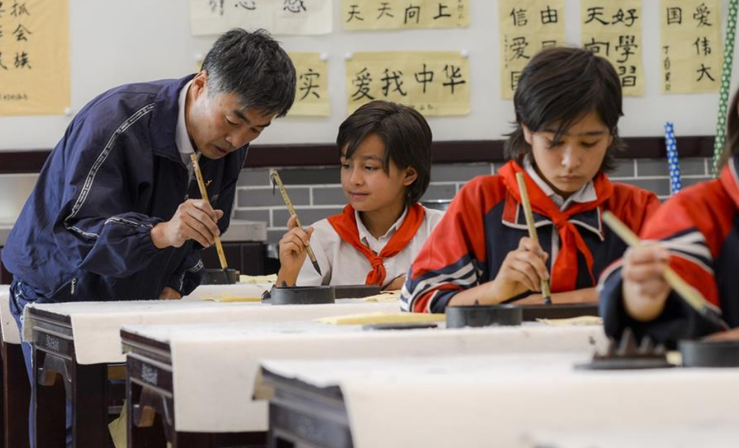 新疆疏附县托克扎克镇中心小学书法教室内，同学们正在学习写毛笔字。