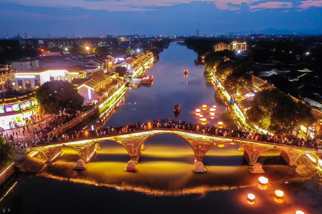 10月2日,游客在塘栖古镇的广济桥观赏运河夜景(无人机照片)。新华社记者 徐昱 摄