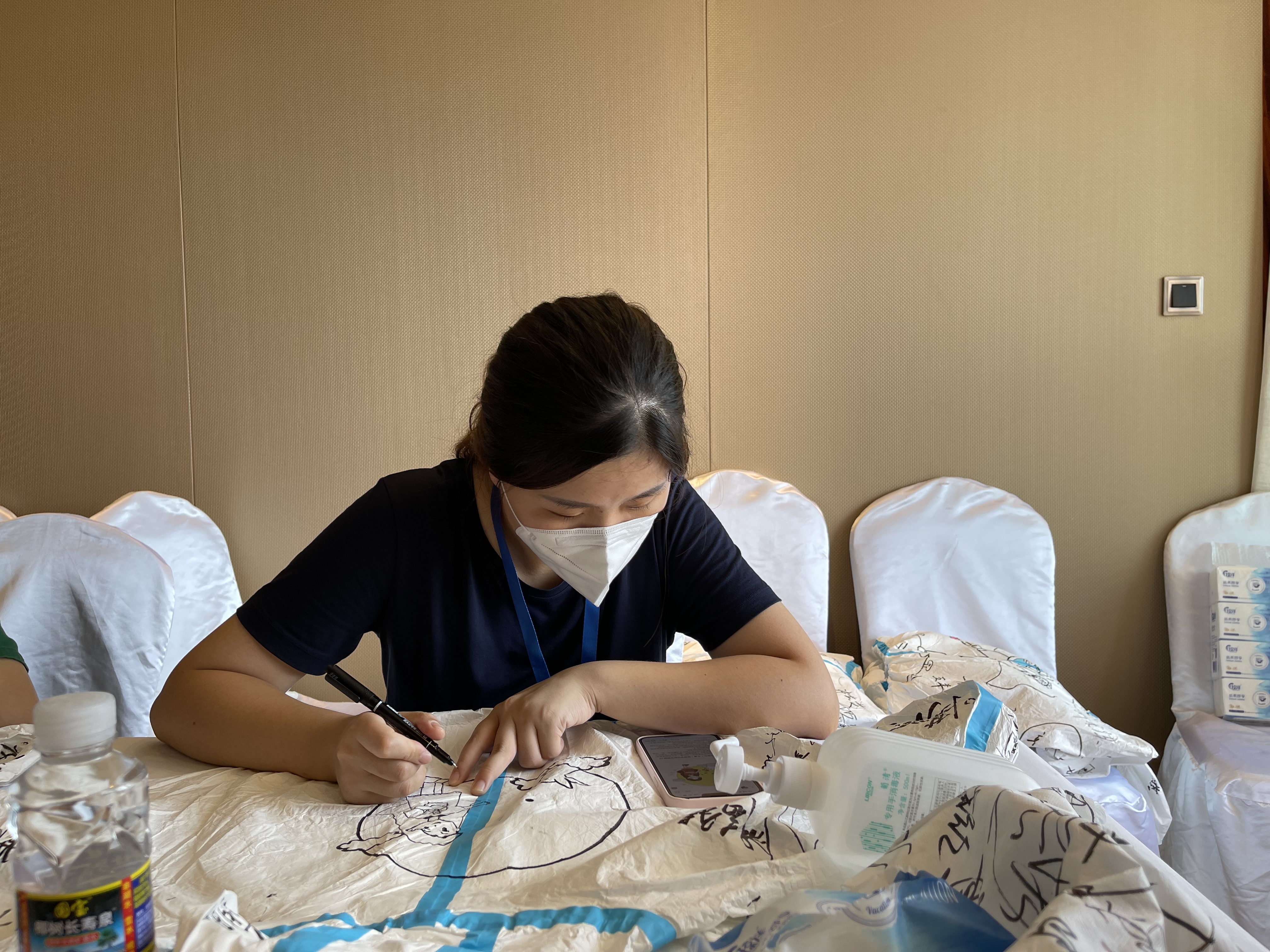 周璇在防护服上绘制卡通画。通讯员供图
