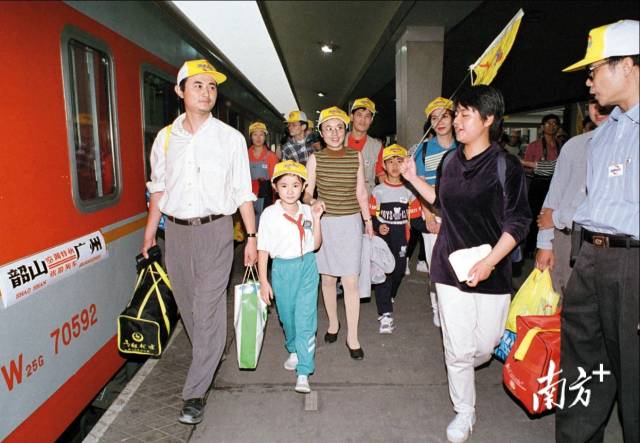 1997年，广州火车站，旅客在导游引导下登车。