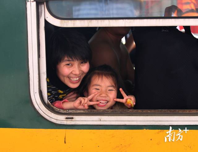 2014年1月，在广州火车站的列车上，一对母女面对记者镜头满脸笑容。